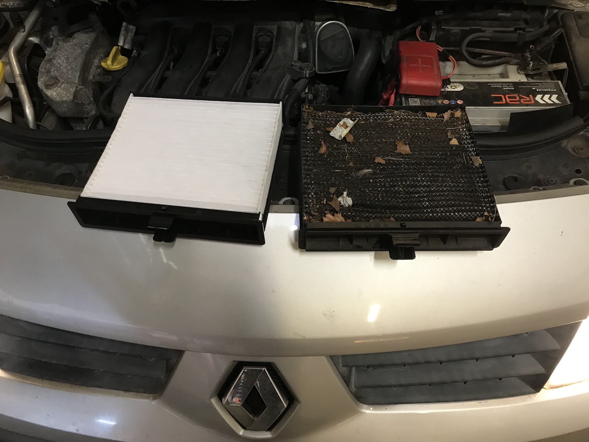 A new cabin filter next to the old dirty one on a Renault