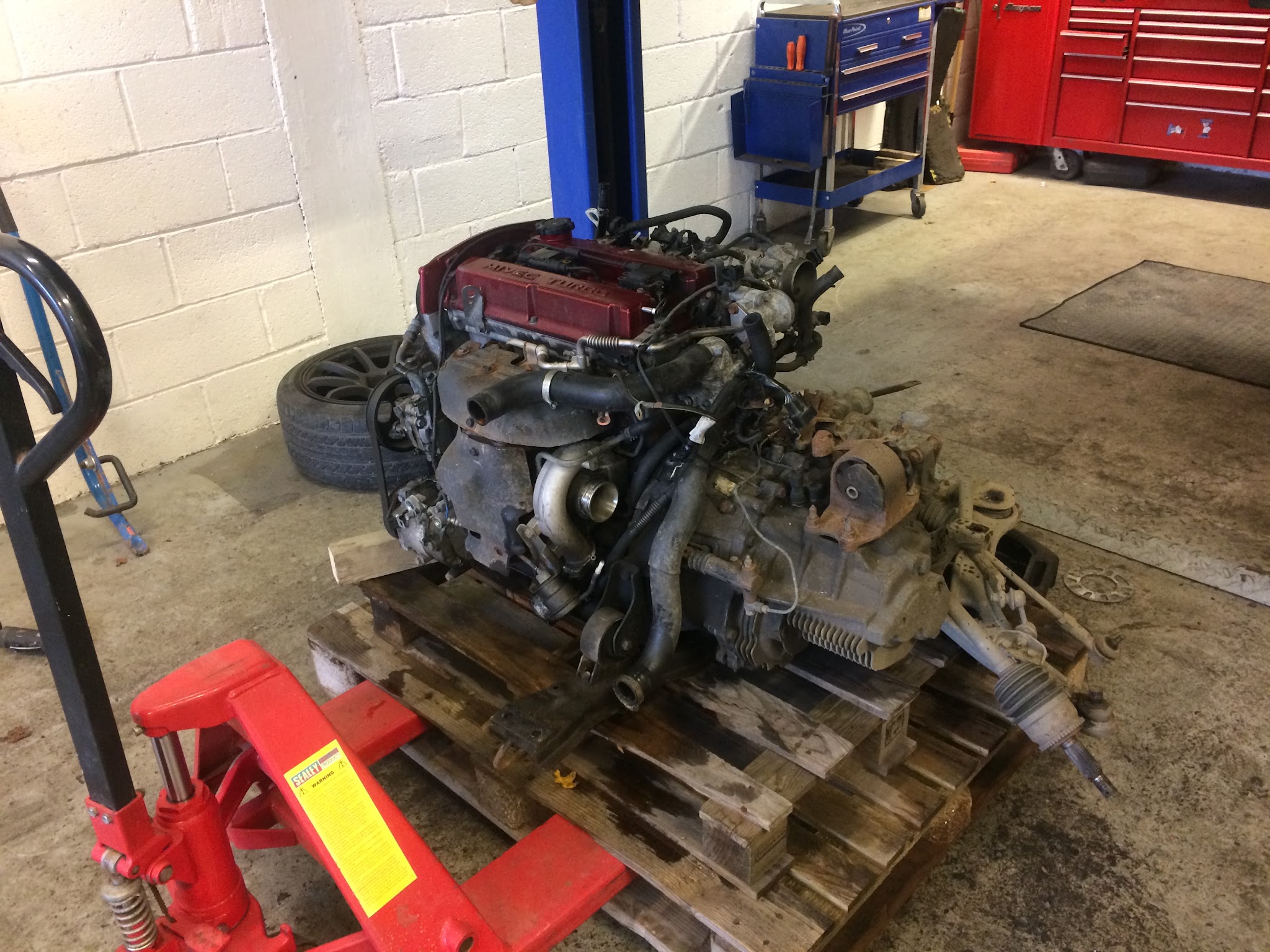 An engine and gearbox out of the car on a pallet